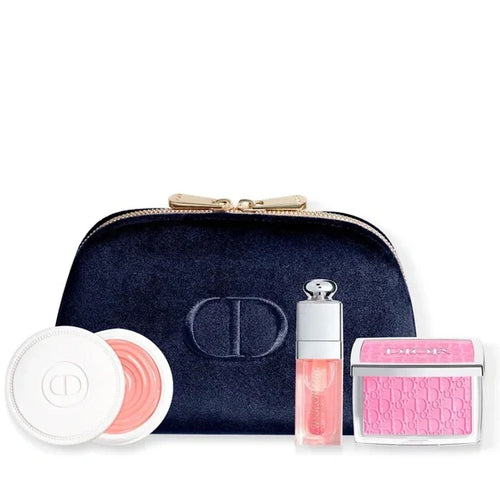 Dior makeup set with navy pouch, pink lip gloss, and blush on a white background